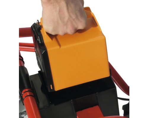 Hand plaatst accu in tuingereedschap