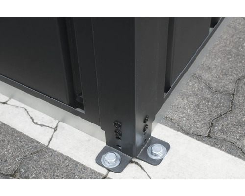 Detailopname van een hekbevestiging met schroeven op de grond