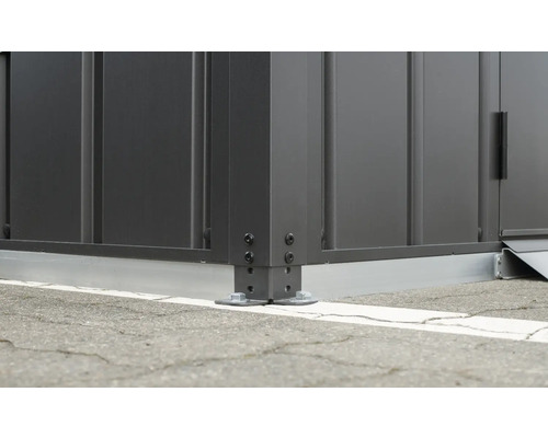 Detailopname van een metalen tuinhuis met schroefbevestiging aan de grond