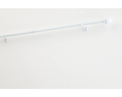 Witte gordijnroede met beugel aan een muur gemonteerd.