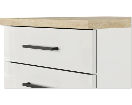 Detailaanzicht van een wit lade-element met houten blad en zwarte handgrepen