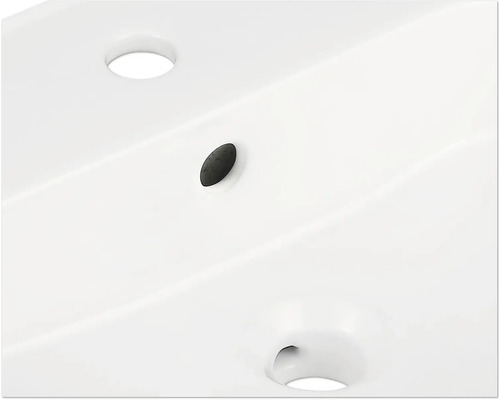 Detailopname van een wastafel met kraangat en overloop