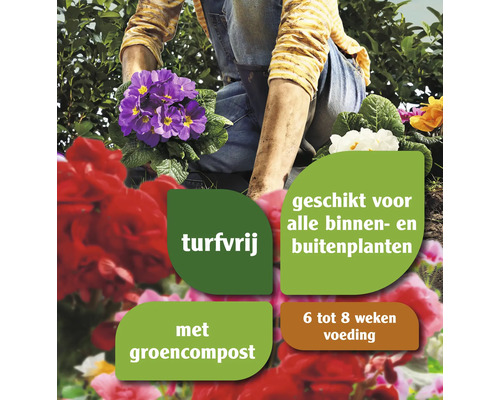 Een persoon plant bloemen met turfvrije potgrond, geschikt voor alle binnen- en buitenplanten, met groencompost en voeding voor zes tot acht weken.