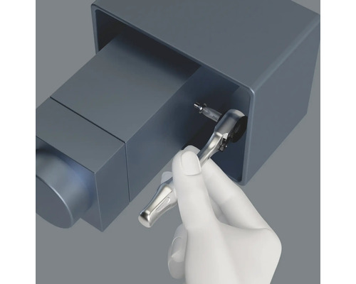 Een hand gebruikt een ratel om een schroef vast te draaien.