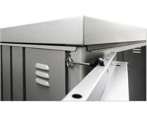 Detailopname van een metalen tuinhuis met ventilatieopeningen en vergrendelingsmechanisme