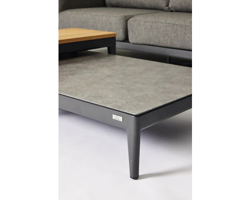 Detailopname van een tuintafel met een grijs tafelblad en een donker frame.