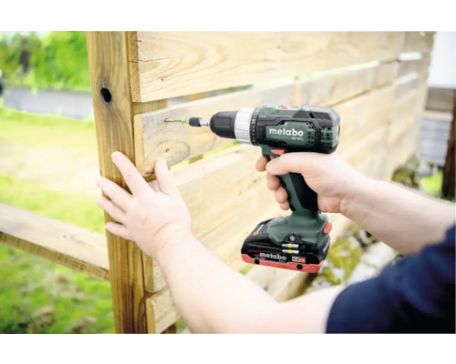 Accuboormachine die een schroef in een houten plank schroeft.