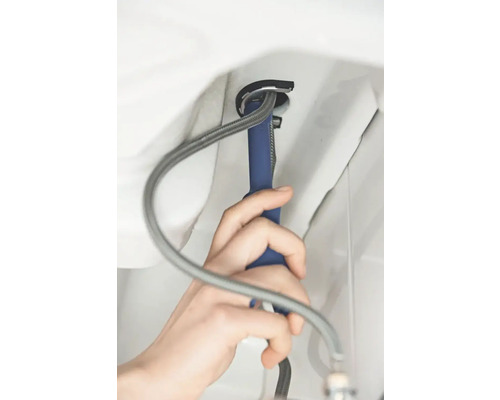 Een persoon monteert een wastafel met een montagesleutel.