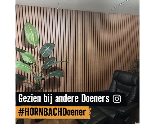 Wanddecoratie met houten panelen, fauteuil en plant in de kamer