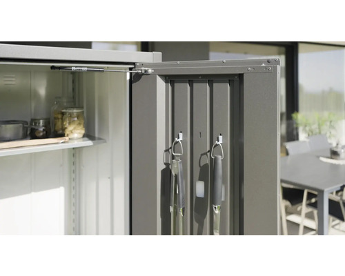 Geopende gereedschapskast met planken en barbecue-accessoires aan de deur