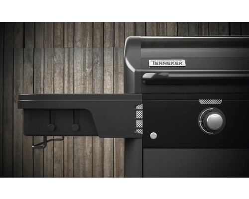 Detailopname van een zwarte gasbarbecue met zijplank en Tenneker logo.