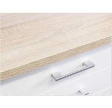 Detailopname van een ladekast met lichtbruin houten blad en zilverkleurige handgrepen