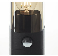 Close-up van een zwarte buitenlamp met bewegingsmelder en gloeilamp