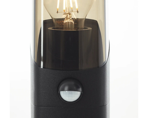 Close-up van een zwarte buitenlamp met bewegingsmelder en gloeilamp