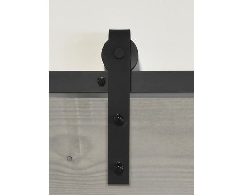 Detail van een metalen schuifdeur rail aan een houten deur