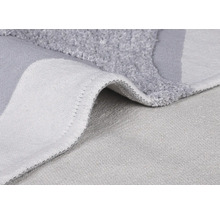 Detailopname van een grijze badmat met pool en geweven achterkant.