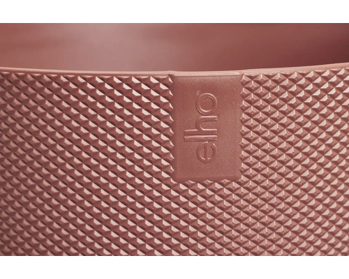 Detailopname van het gestructureerde oppervlak van een bloempot met het Elho logo.