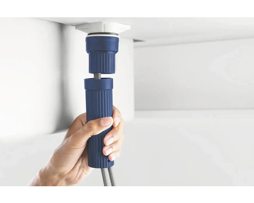 Hand houdt een blauwe sifon vast voor installatie onder een wastafel.