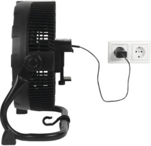 Zwarte ventilator met adapter aangesloten op een stopcontact