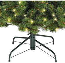 Detailopname van een kerstboom met verlichting en een kerstboomstandaard