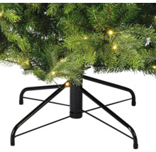 Detailopname van een kunstkerstboom met verlichting en een zwart metalen onderstel