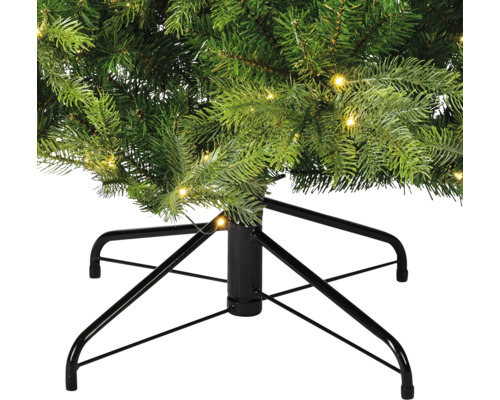 Detailopname van een kunstkerstboom met verlichting en een zwart metalen onderstel