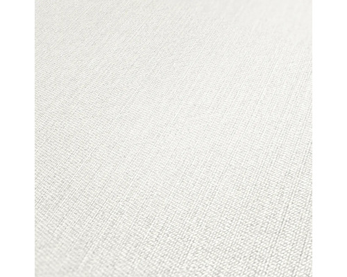 Close-up van een wit vliesbehang met een subtiele textielstructuur