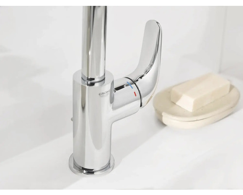 Glanzende kraan van Grohe naast zeep