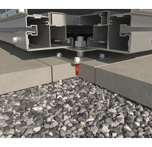 Detailopname van een terrasconstructie van metaal, bevestigd op stenen platen en een grindbed.