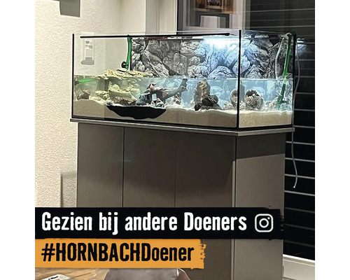 Aquarium met rotsen en decoratie op een kast