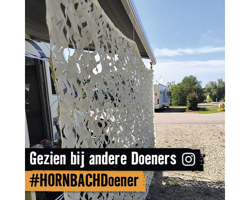 Camouflagenet als privacyscherm bij caravan