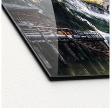 Detailopname van een acrylglasfoto met een bergmeer en een houten steiger
