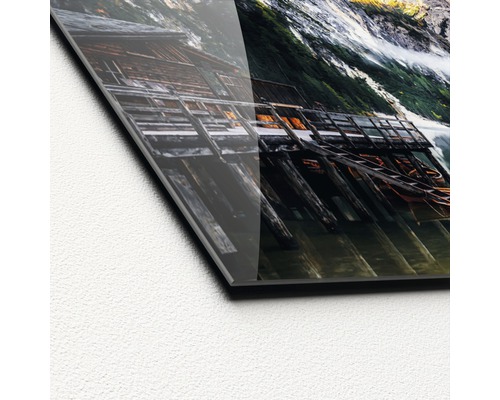 Detailopname van een acrylglasfoto met een bergmeer en een houten steiger