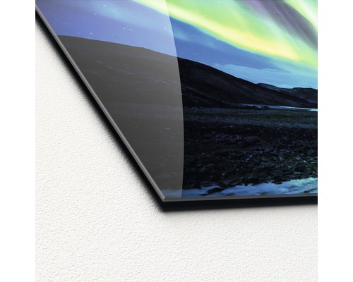 Detailopname van een acrylglasfoto met een motief van het noorderlicht boven een berglandschap