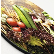 Groenteselectie op een houten plank: courgette, tomaten, sla en andere groenten.