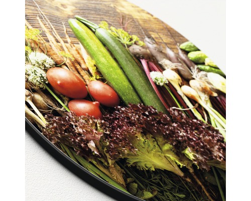 Groenteselectie op een houten plank: courgette, tomaten, sla en andere groenten.