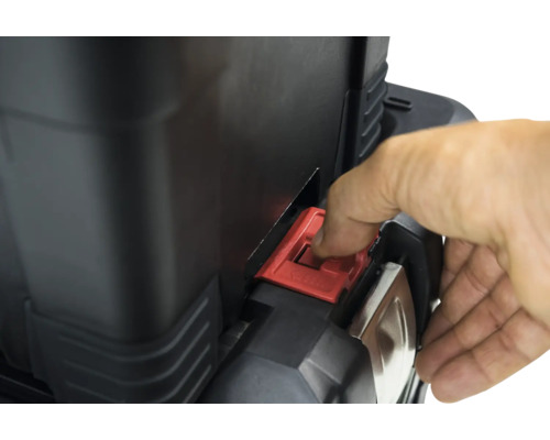 Detailopname van een gereedschapskist met rode sluiting die door een hand wordt bediend.