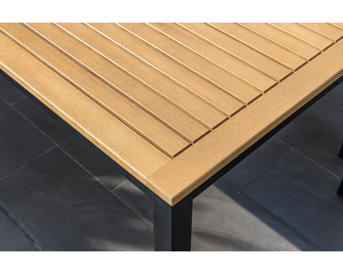 Gedetailleerd beeld van een houten tuintafelblad met een zwart tafelonderstel.