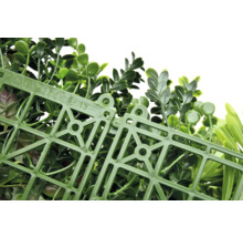 Kunstmatige plantenwand met groene bladeren en kunststof rooster