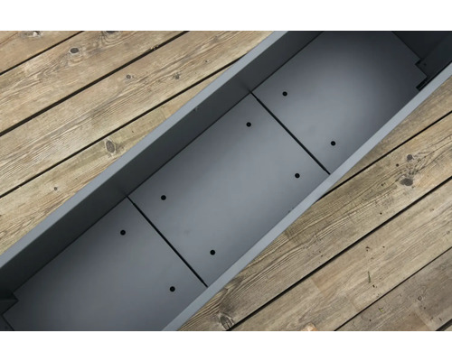 Lege, grijze plantenbak op een houten vloer