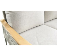 Close-up van een bank met houten armleuning en lichte kussens