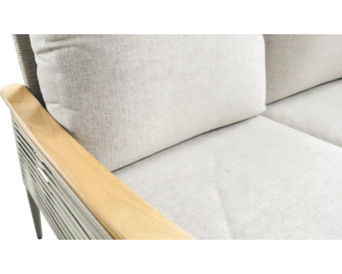 Close-up van een bank met houten armleuning en lichte kussens