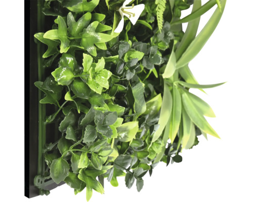 Kunstmatige plantenwand met verschillende groene bladeren en een witte bloem