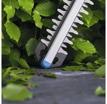 Close-up van een heggenschaar in gebruik op een heg