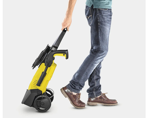 Een persoon trekt een gele hogedrukreiniger.