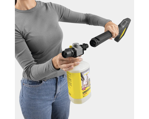 Een vrouw bevestigt een spuitmondstuk aan een fles universele reiniger voor hogedrukreinigers.