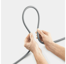 Grijs irrigatieslang wordt vastgehouden door twee handen