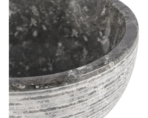 Close-up van een grijze stenen plantenschaal met een gegroefd oppervlak.