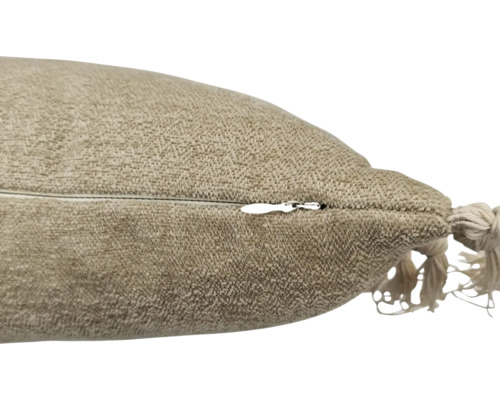 Detailweergave van een kussen met ritssluiting en decoratieve kwast