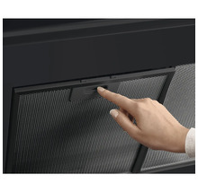 Een hand bedient het filter van een afzuigkap.